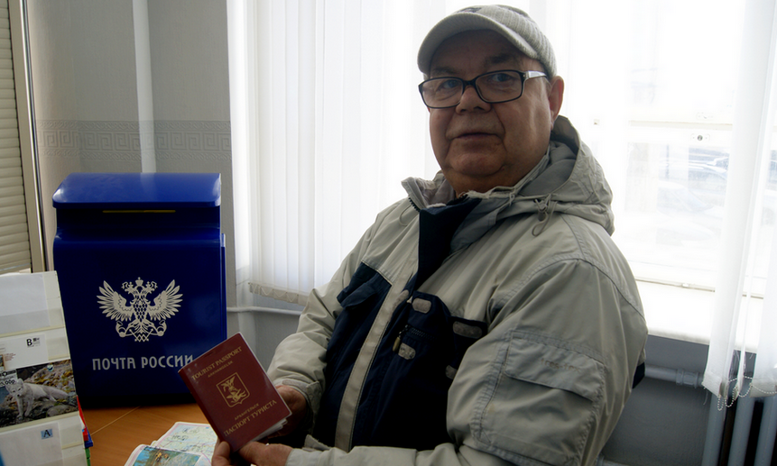 Путешественник Николай Попов со своим проштампованным паспортом туриста. Фото ИА «Регион 29».